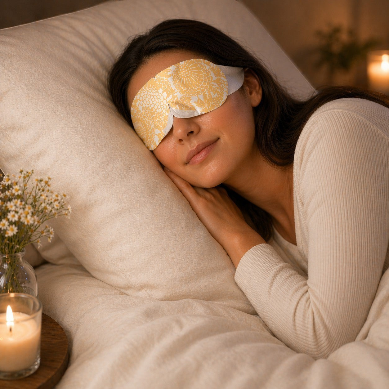 SlumberHush WarmEye steam mask in yellow floral pattern, worn by a woman sleeping peacefully in bed.