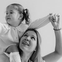 Black and white photo of a woman and child with a plain background