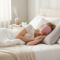 SlumberHush DeepShield™ pink sleep mask on a woman sleeping comfortably in bed.