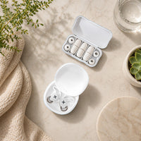 SlumberHush QuietSeal earplugs in white, with a charging case and spare ear tips.