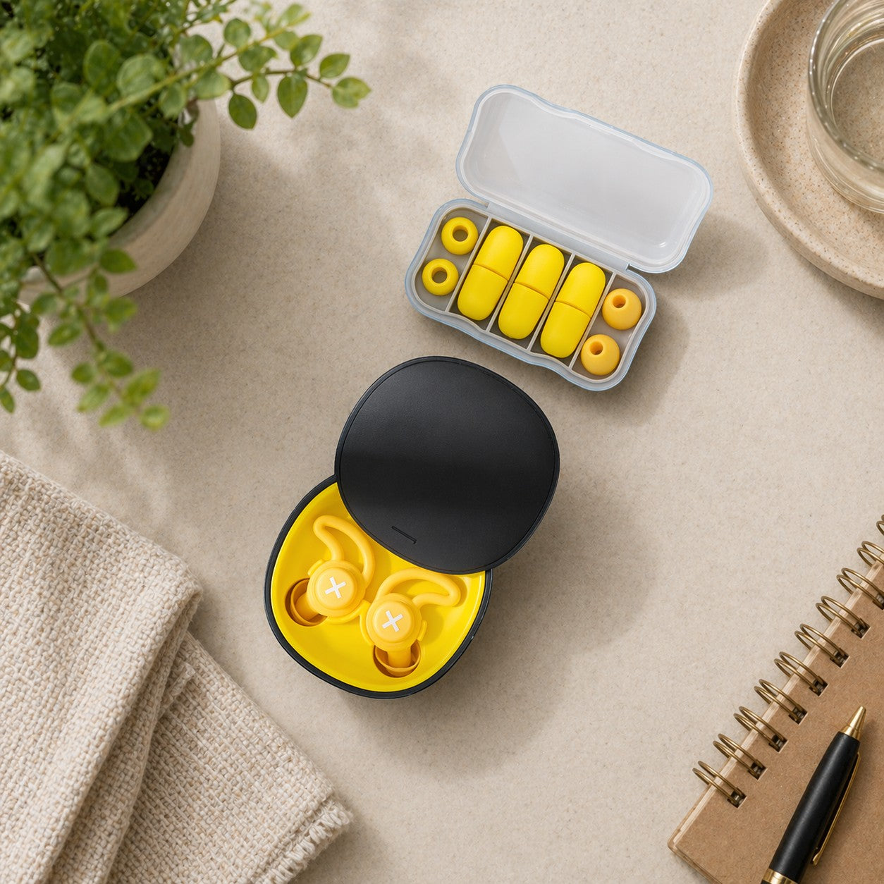 SlumberHush QuietSeal earplugs in yellow, with a charging case and a separate travel case containing spare ear tips.